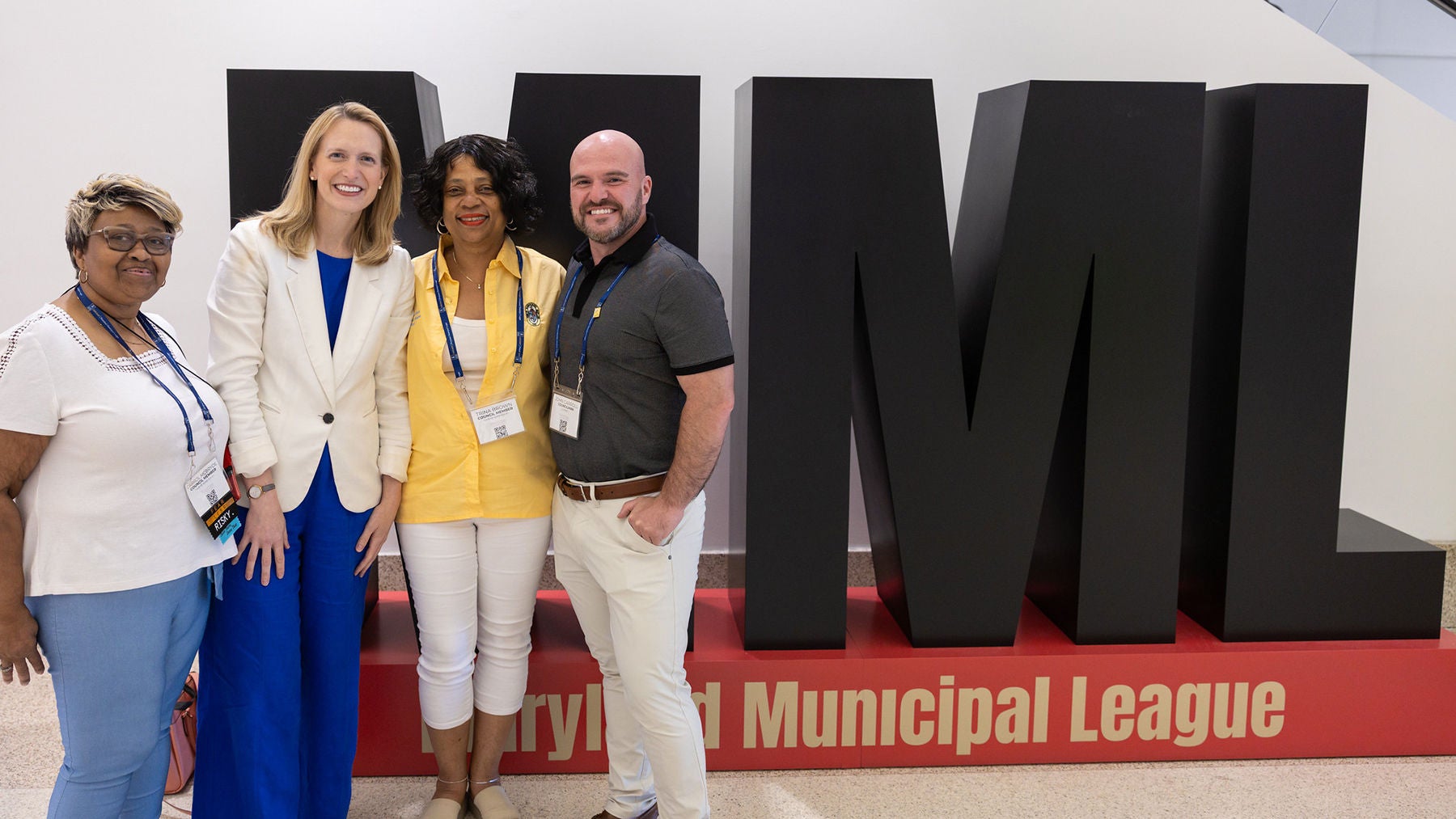 Comptroller Lierman standing with three others in front of the MML logo