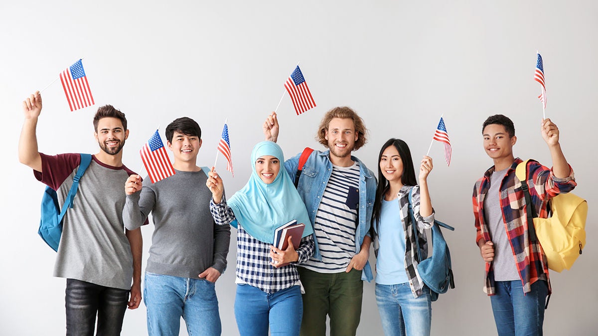 Group of students with USA flags on light background