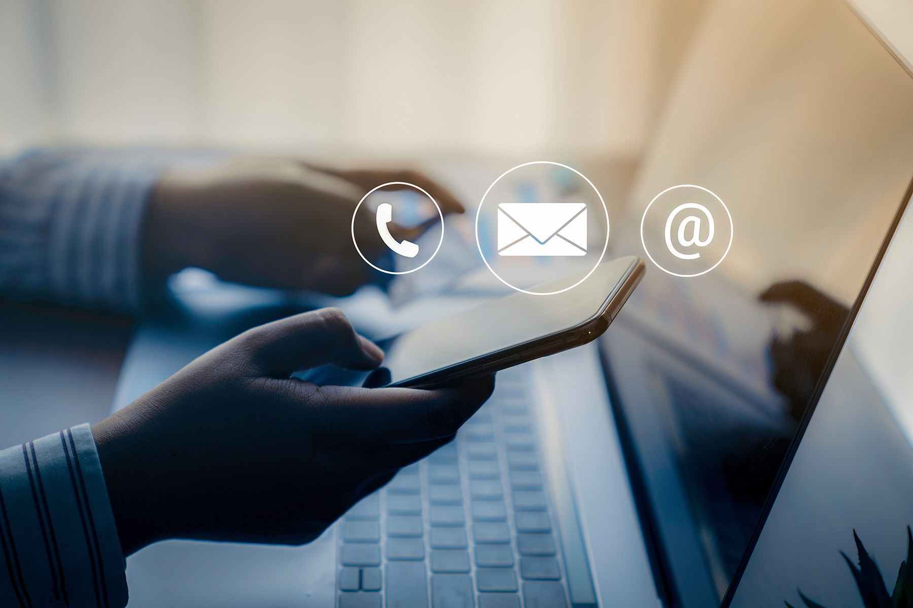Businessman using a mobile phone with the (email, call phone, mail) icons.