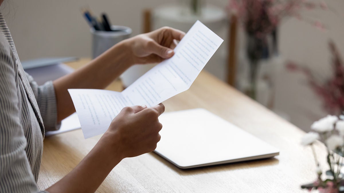 Close up young woman holding paper letter
