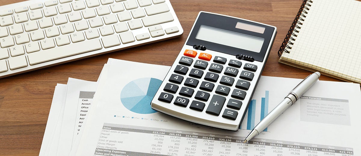 Calculator and financial chart report on wooden table