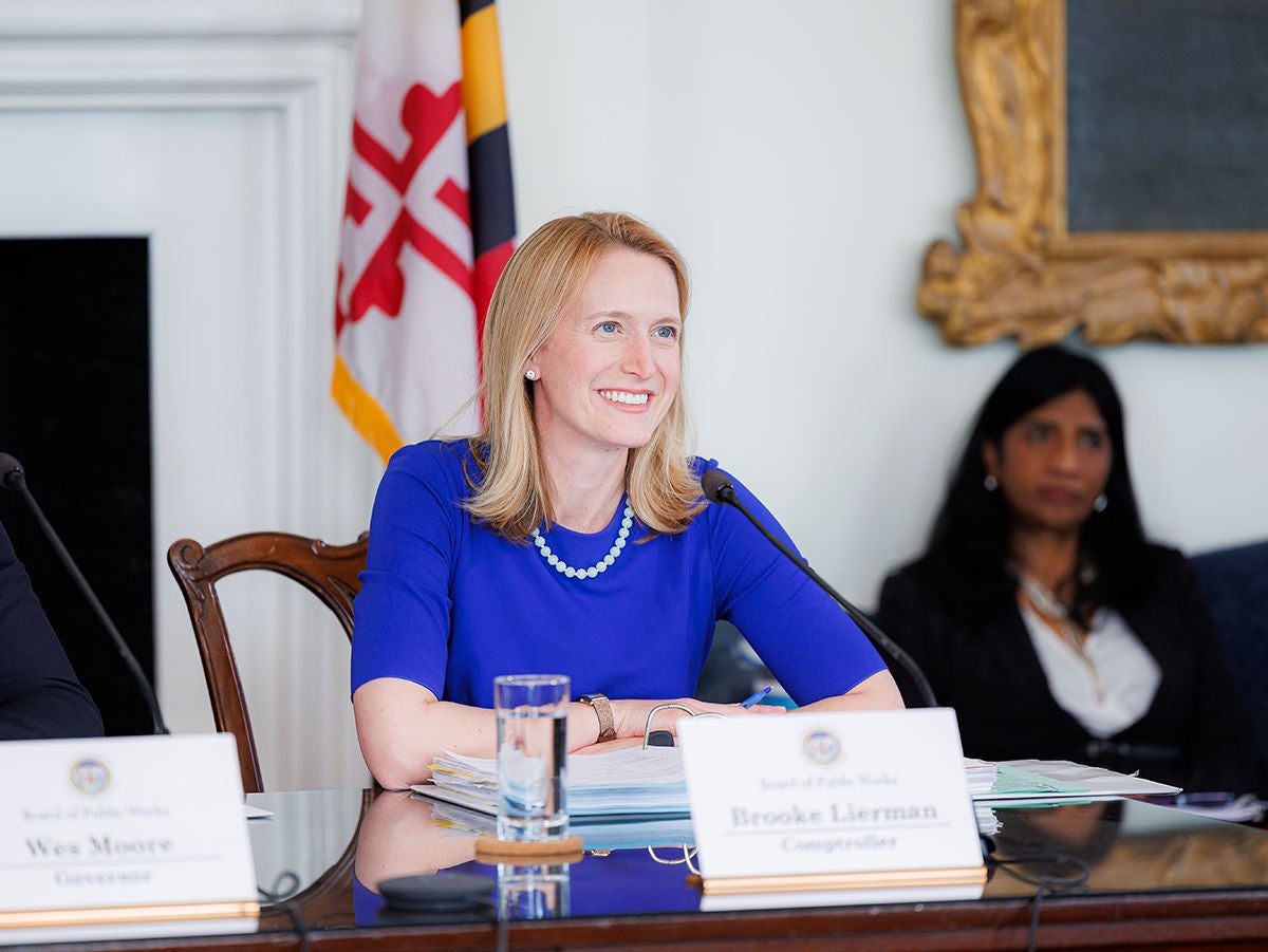 Comptroller Lierman sitting at a desk smiling 