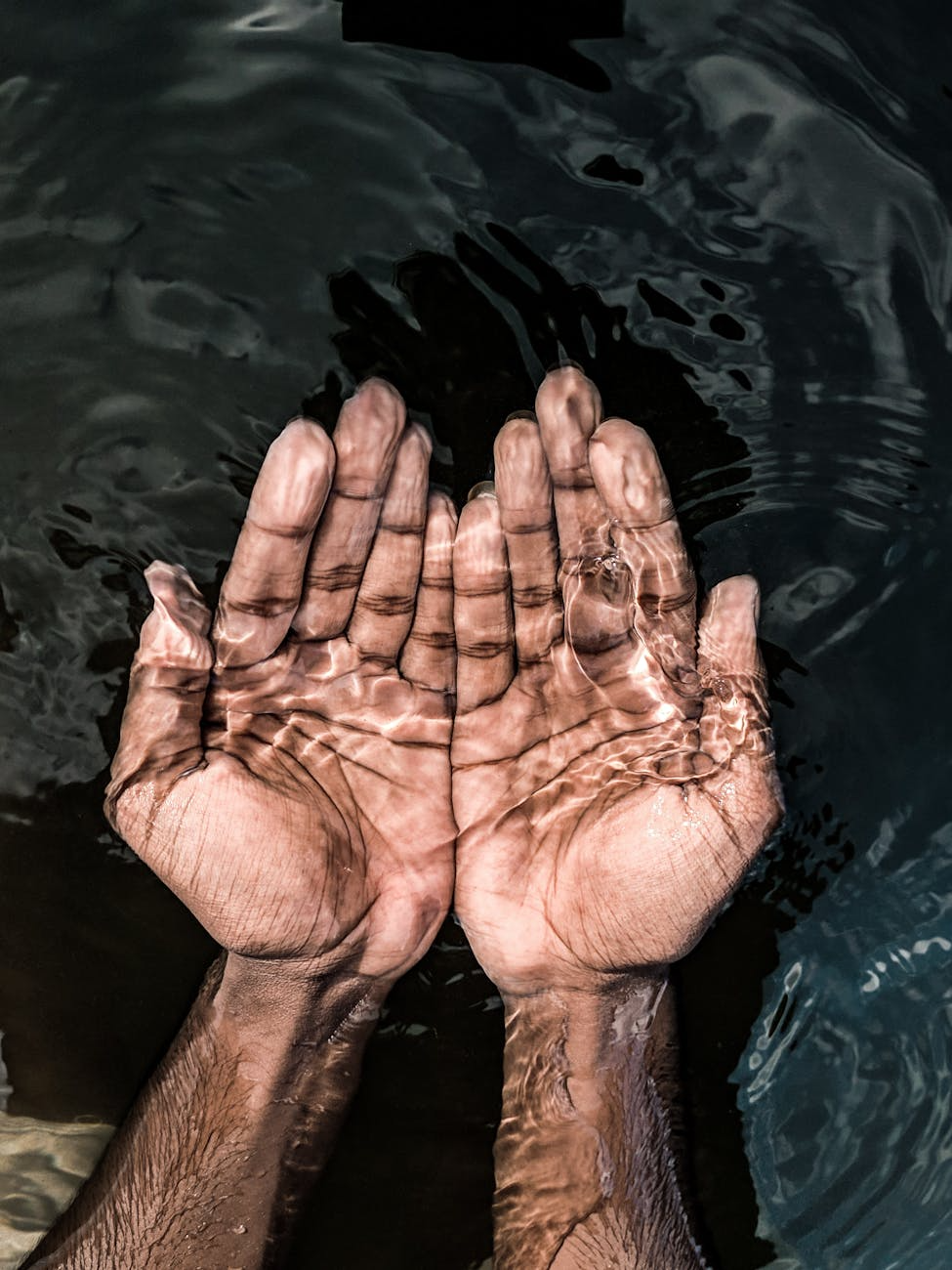 Two hands showing through clear water