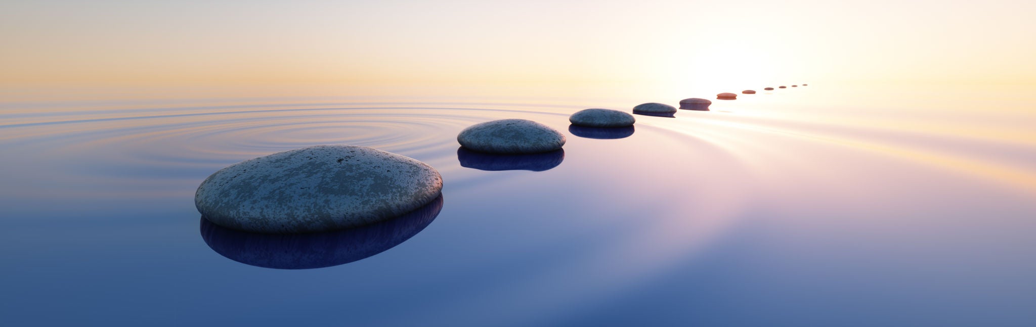 Rocks on the water with the sun setting