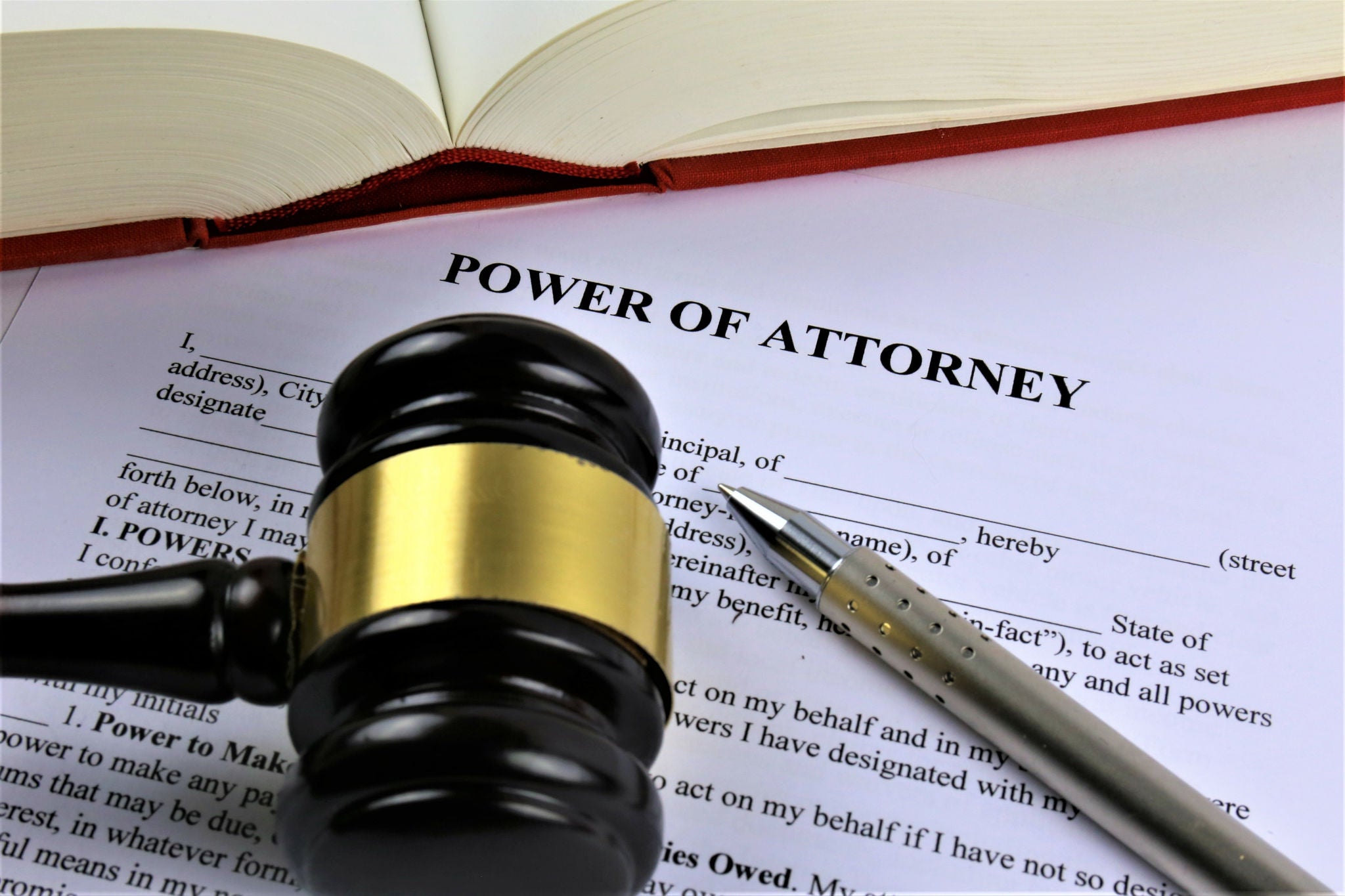 A gavel and pen on top of power of attorney papers