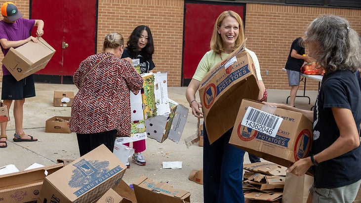 Comptroller Lierman breaking down boxes with a group of people at a food distribution event.