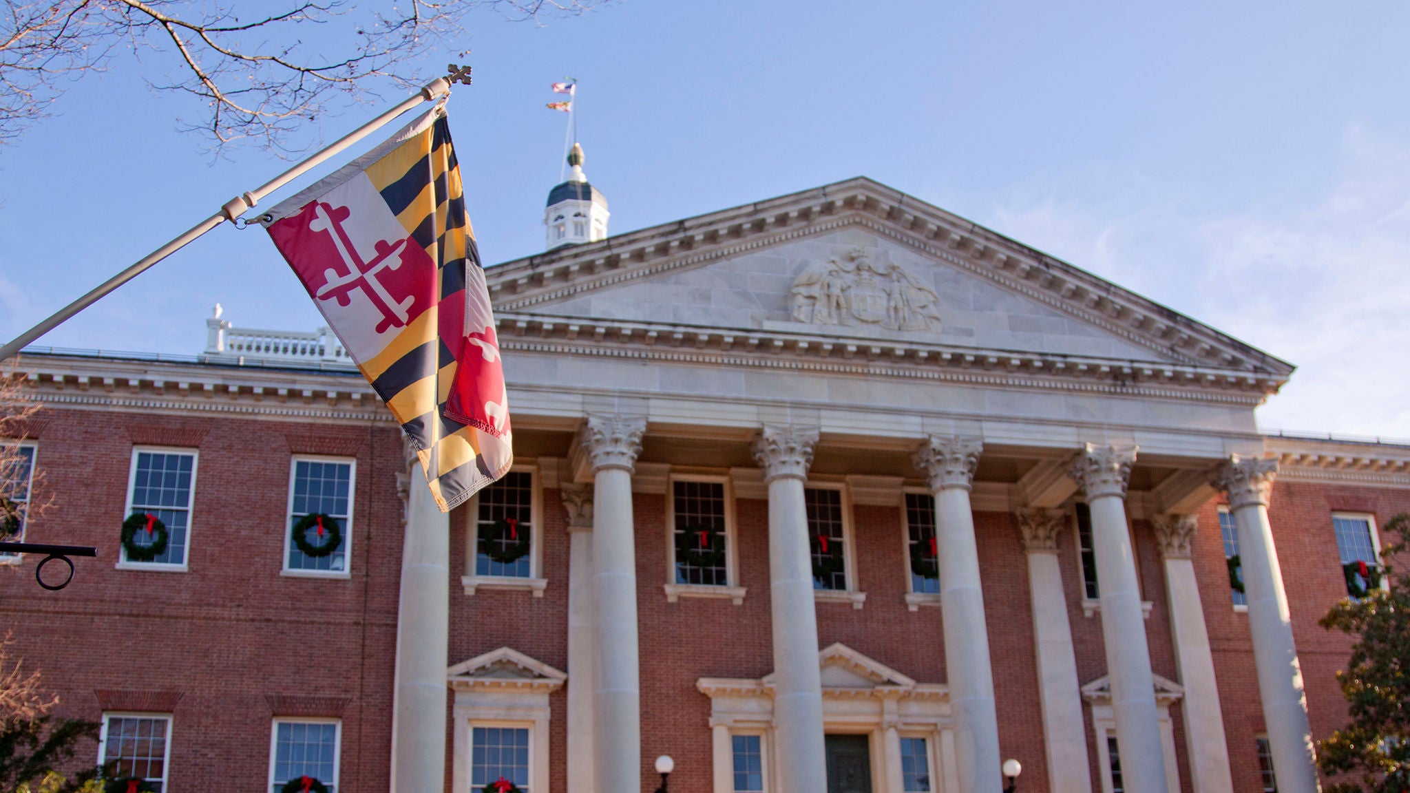 Low angle view of Maryland state flag in front of the capitol state house in Annapolis, MD.