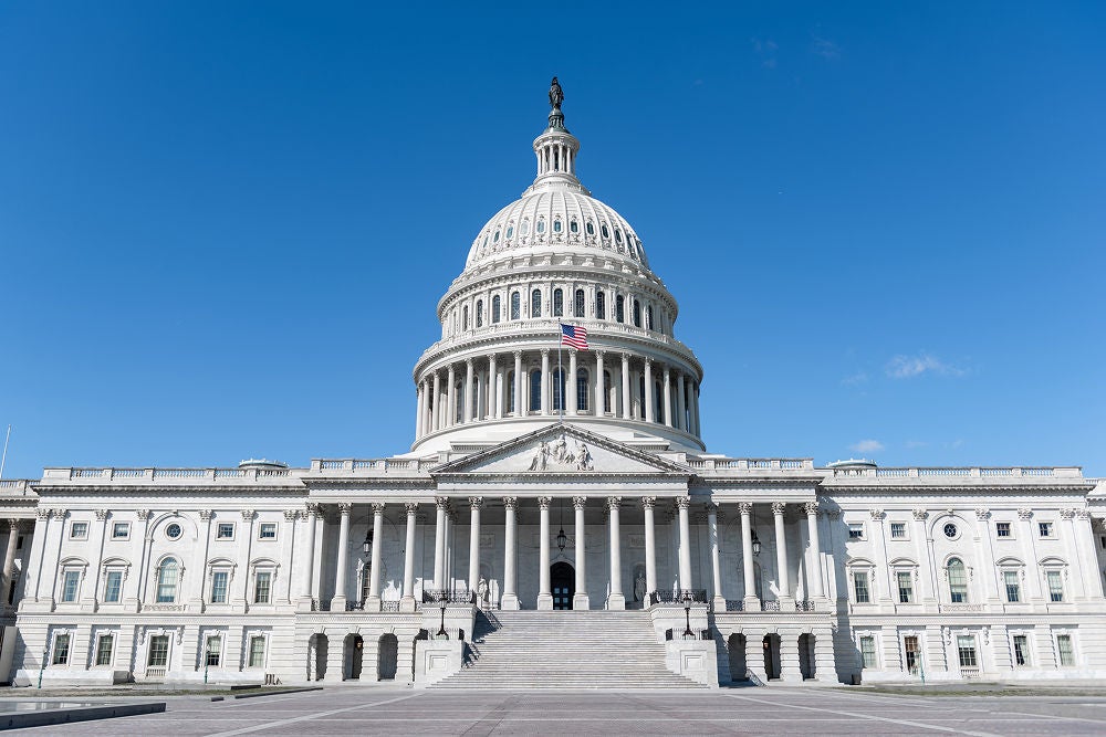 Capitol building with large white dome and American Flag